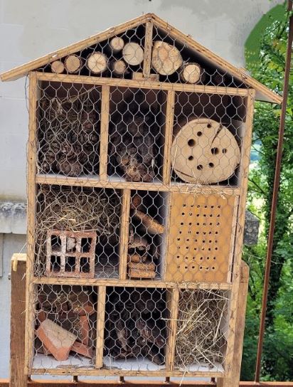 Bug hotel with logs, straw, pots and hidey holes for various insects